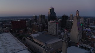 DX0001_001385 - 5.7K aerial stock footage static view of city skyscrapers lit up for the evening at twilight in Downtown Kansas City, Missouri