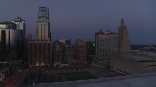 DX0001_001392 - 5.7K aerial stock footage a view of a downtown hotel between skyscrapers at twilight in Downtown Kansas City, Missouri