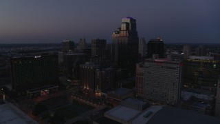 DX0001_001397 - 5.7K aerial stock footage of reverse view of skyscrapers, hotels and city park at twilight in Downtown Kansas City, Missouri