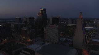 DX0001_001398 - 5.7K aerial stock footage flyby and descend with view of hotel and skyscrapers at twilight in Downtown Kansas City, Missouri