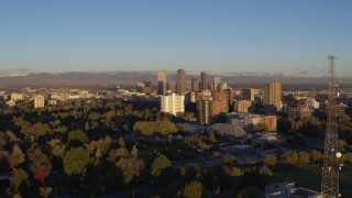 DX0001_001408 - 5.7K aerial stock footage flyby radio tower near apartment buildings for view of skyscrapers at sunrise, Downtown Denver, Colorado
