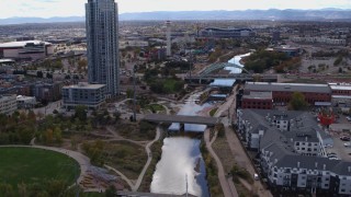 DX0001_001502 - 5.7K aerial stock footage follow South Platte River to approach bridges and skyscraper in Downtown Denver, Colorado