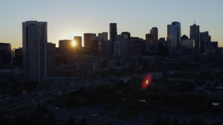 DX0001_001610 - 5.7K aerial stock footage of the city skyline behind residential skyscraper at sunrise, Downtown Denver, Colorado
