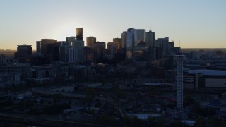DX0001_001619 - 5.7K aerial stock footage flyby theme park for view of bright sun and city skyline at sunrise in Downtown Denver, Colorado
