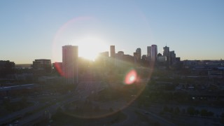 DX0001_001621 - 5.7K aerial stock footage ascend for stationary view of bright sun and city skyline at sunrise in Downtown Denver, Colorado