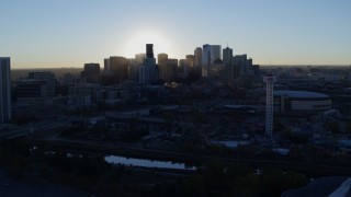 DX0001_001622 - 5.7K aerial stock footage flyby bright sun and city skyline, seen from theme park and arena at sunrise in Downtown Denver, Colorado