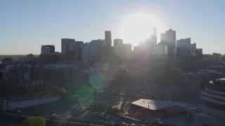 DX0001_001632 - 5.7K aerial stock footage flyby arena to focus on sun behind city's skyline at sunrise in Downtown Denver, Colorado