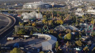 DX0001_001635 - 5.7K aerial stock footage reverse view of rides at Elitch Gardens at sunrise in Downtown Denver, Colorado