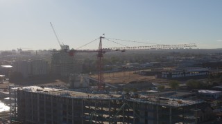 DX0001_001649 - 5.7K aerial stock footage of a crane atop a building under construction at sunrise in Downtown Denver, Colorado