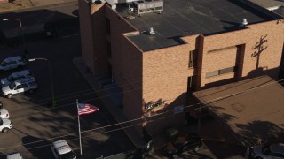 DX0001_001764 - 5.7K aerial stock footage of a brick police station and flag in Denver, Colorado