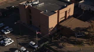 DX0001_001765 - 5.7K aerial stock footage of a reverse view of a brick police station and flag in Denver, Colorado