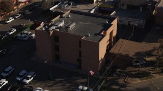 DX0001_001767 - 5.7K aerial stock footage of flying away from a brick police station in Denver, Colorado