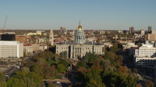 DX0001_001783 - 5.7K aerial stock footage of flying by Colorado State Capitol and tree-lined park in Downtown Denver, Colorado