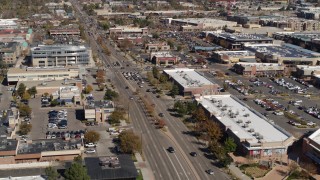 DX0001_001949 - 5.7K aerial stock footage of reverse view of a strip mall beside a wide street in Boulder, Colorado