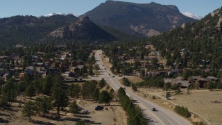 DX0001_001976 - 5.7K aerial stock footage of descending past cars on a road through the town of Estes Park, Colorado