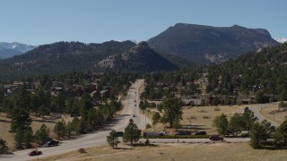 DX0001_001977 - 5.7K aerial stock footage reverse view of cars on a road through the town of Estes Park, Colorado
