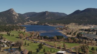 DX0001_001984 - 5.7K aerial stock footage descend with focus on Lake Estes, golf course and green mountains in Estes Park, Colorado