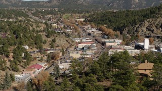 DX0001_001989 - 5.7K aerial stock footage fly over trees to reveal shops on road through Estes Park, Colorado