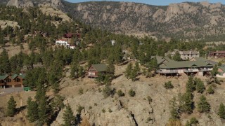 DX0001_002005 - 5.7K aerial stock footage orbit rural hillside homes near rugged mountains in Estes Park, Colorado