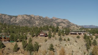 DX0001_002008 - 5.7K aerial stock footage of a view of rural hillside homes near rugged mountains during descent in Estes Park, Colorado