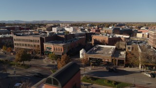 DX0001_002022 - 5.7K aerial stock footage fly away from shops and office buildings before ascent in Fort Collins, Colorado