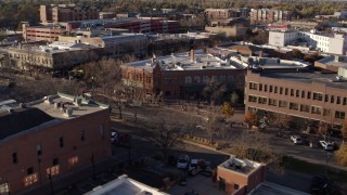 DX0001_002043 - 5.7K aerial stock footage of flying by brick office buildings and street level shop in Fort Collins, Colorado