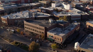 DX0001_002057 - 5.7K aerial stock footage orbit a shop with green awning and brick office building in Fort Collins, Colorado
