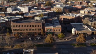 DX0001_002060 - 5.7K aerial stock footage of people and cars passing a shop with green awning and brick office building in Fort Collins, Colorado