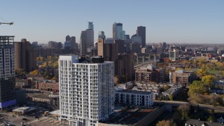 DX0001_002117 - 5.7K aerial stock footage of city's skyline and an apartment building at sunrise in Downtown Minneapolis, Minnesota