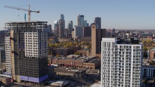 DX0001_002118 - 5.7K aerial stock footage of flyby apartment building at sunrise with skyline in background in Downtown Minneapolis, Minnesota