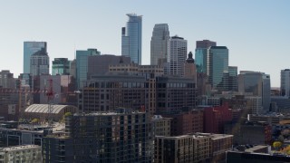 DX0001_002164 - 5.7K aerial stock footage descend by office building and construction, city's skyline in background, Downtown Minneapolis, Minnesota