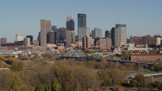 DX0001_002180 - 5.7K aerial stock footage ascend from trees to a stationary view of the city skyline, Downtown Minneapolis, Minnesota
