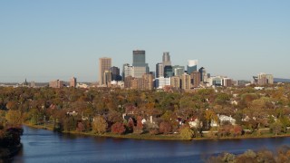 DX0001_002190 - 5.7K aerial stock footage of the city's skyline seen while flying by lakefront homes, Downtown Minneapolis, Minnesota