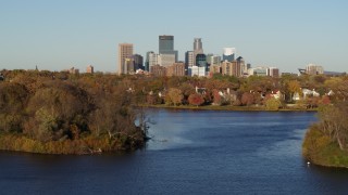 DX0001_002193 - 5.7K aerial stock footage of the city's skyline seen while passing by lakeside houses, Downtown Minneapolis, Minnesota