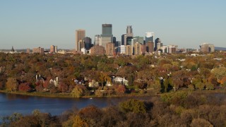 DX0001_002204 - 5.7K aerial stock footage ascend from Lake of the Isles to reveal homes and city skyline, Downtown Minneapolis, Minnesota