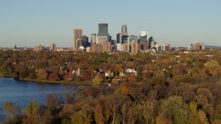 DX0001_002209 - 5.7K aerial stock footage of the skyline of Downtown Minneapolis, Minnesota seen from homes by the lake