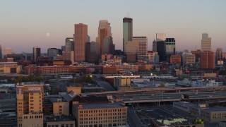 DX0001_002237 - 5.7K aerial stock footage reverse view of the city's skyline at sunset with moon in the sky, Downtown Minneapolis, Minnesota