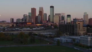 DX0001_002242 - 5.7K aerial stock footage reverse view of city's skyline at sunset, seen from park, Downtown Minneapolis, Minnesota