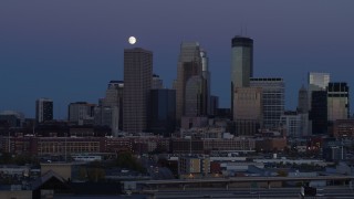 DX0001_002263 - 5.7K aerial stock footage of passing by the city's skyline at twilight with moon in the sky, Downtown Minneapolis, Minnesota