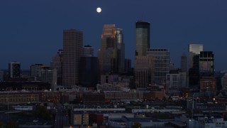 DX0001_002273 - 5.7K aerial stock footage of the moon above skyscrapers in city skyline at twilight, Downtown Minneapolis, Minnesota
