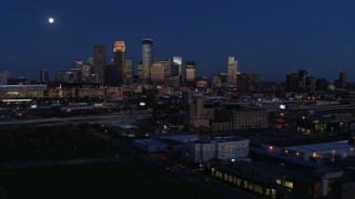 DX0001_002282 - 5.7K aerial stock footage flying by market building with the moon above city's downtown skyline at twilight, Downtown Minneapolis, Minnesota