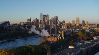 DX0001_002289 - 5.7K aerial stock footage ascend to reveal power plant, and the city skyline across the river at sunrise, Downtown Minneapolis, Minnesota