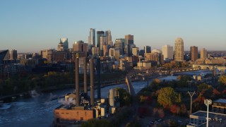 DX0001_002290 - 5.7K aerial stock footage flyby power plant and bridge with the city skyline across the river at sunrise, Downtown Minneapolis, Minnesota