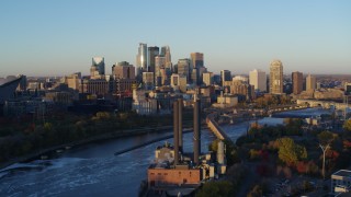 DX0001_002292 - 5.7K aerial stock footage flyby power plant with the city skyline across the river at sunrise, Downtown Minneapolis, Minnesota