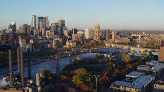 DX0001_002296 - 5.7K aerial stock footage of flying by bridge and Mississippi River at sunrise, with view of skyline, Downtown Minneapolis, Minnesota