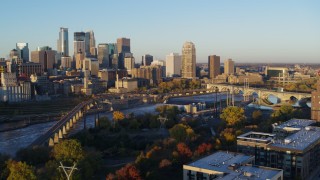 DX0001_002297 - 5.7K aerial stock footage flyby bridge and river at sunrise, reveal power plant, with view of skyline, Downtown Minneapolis, Minnesota