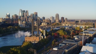 DX0001_002301 - 5.7K aerial stock footage descend with view of power plant and skyline at sunrise, Downtown Minneapolis, Minnesota