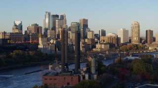 DX0001_002302 - 5.7K aerial stock footage descend past power plant with view of skyline at sunrise, Downtown Minneapolis, Minnesota