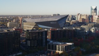 DX0001_002321 - 5.7K aerial stock footage of US Bank Stadium at sunrise while descending, Downtown Minneapolis, Minnesota