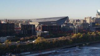 DX0001_002323 - 5.7K aerial stock footage of US Bank Stadium at sunrise, seen while descending across the river, Downtown Minneapolis, Minnesota